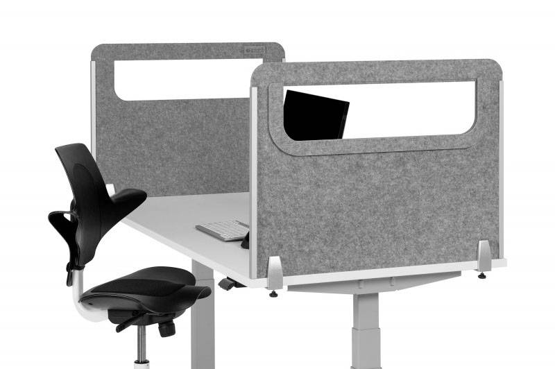 Höhenverstellbarer Schreibtisch mit grauem Sichtschutz, ergonomischem Bürostuhl sowie Tastatur und Monitor darauf platziert.