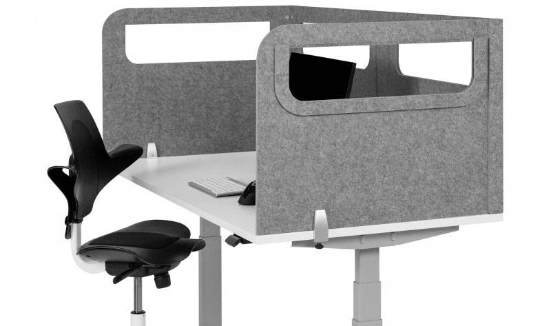 Höhenverstellbarer Schreibtisch mit Trennwand, schwarzem Bürostuhl und Computermonitor. Ideal für konzentriertes Arbeiten.