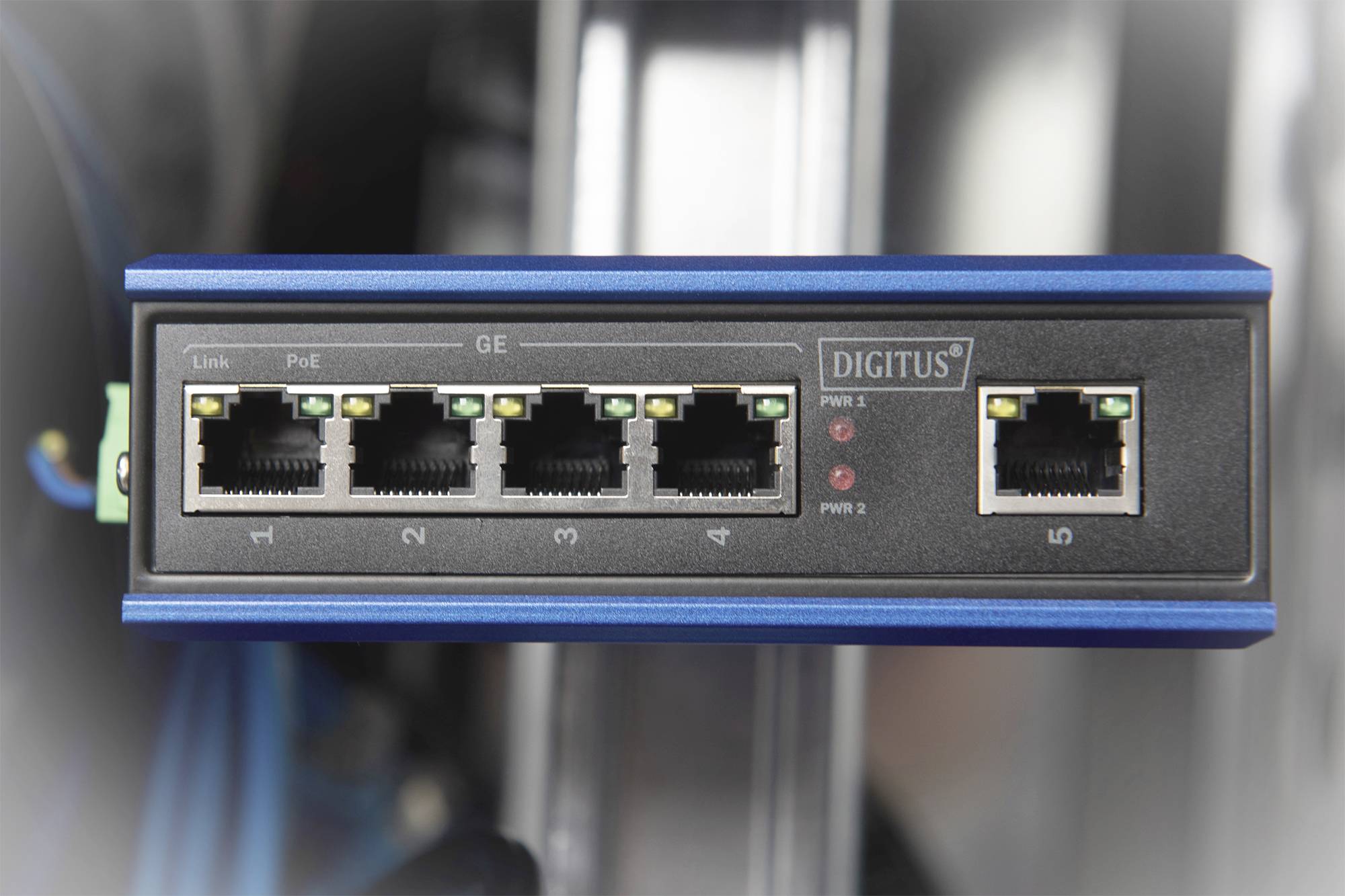 Ein Netzwerk-Switch mit fünf Ethernet-Ports, einer für Power over Ethernet (PoE). Drei LEDs zeigen Verbindungsstatus an.