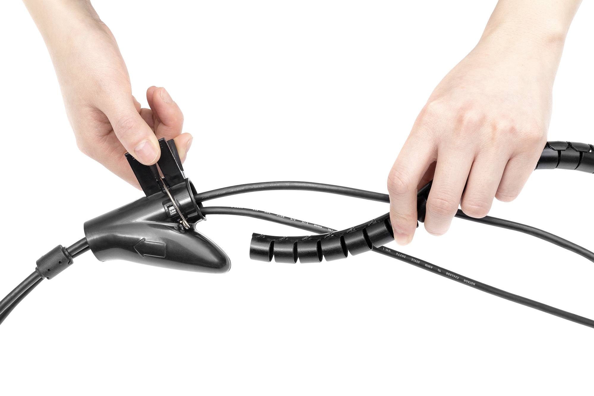 Zwei Hände umwickeln ein schwarzes Kabel mit einer flexiblen Spirale, um es zu bündeln und zu ordnen.