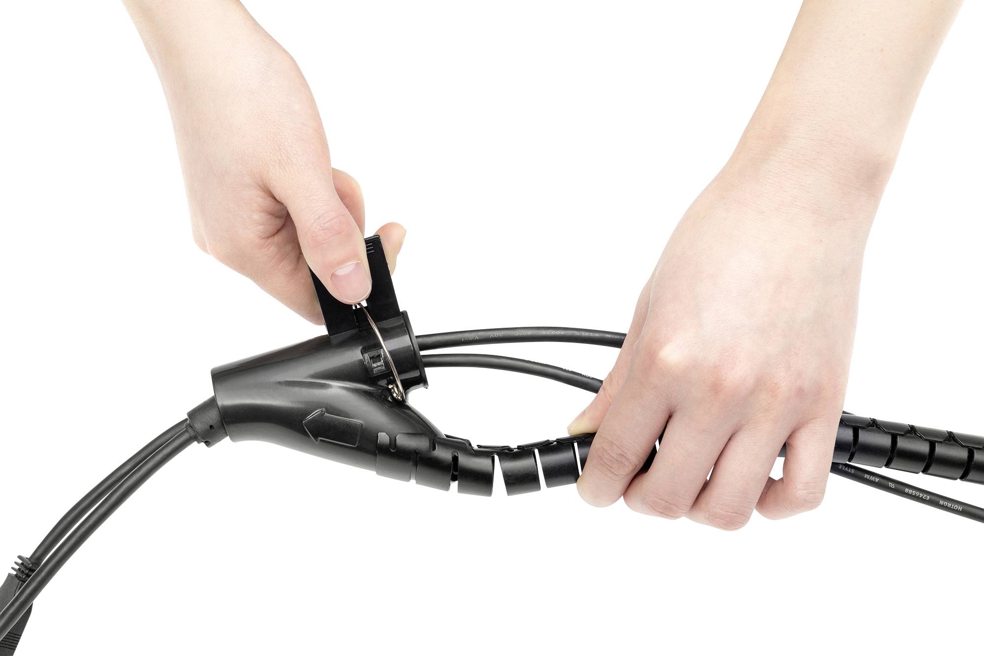 Eine Person montiert Kabel mit einem spiralförmigen Kabelschutz, um die Kabel zu organisieren und zu schützen.