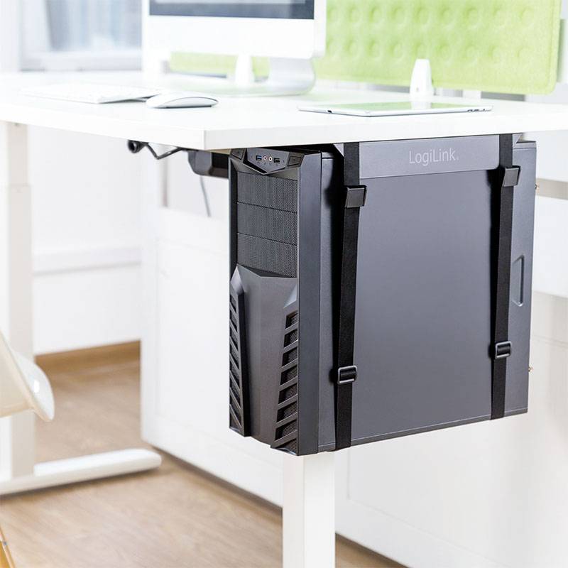Ein Computer-Tower ist unter einem weißen Schreibtisch montiert. Der Raum wirkt hell und modern.