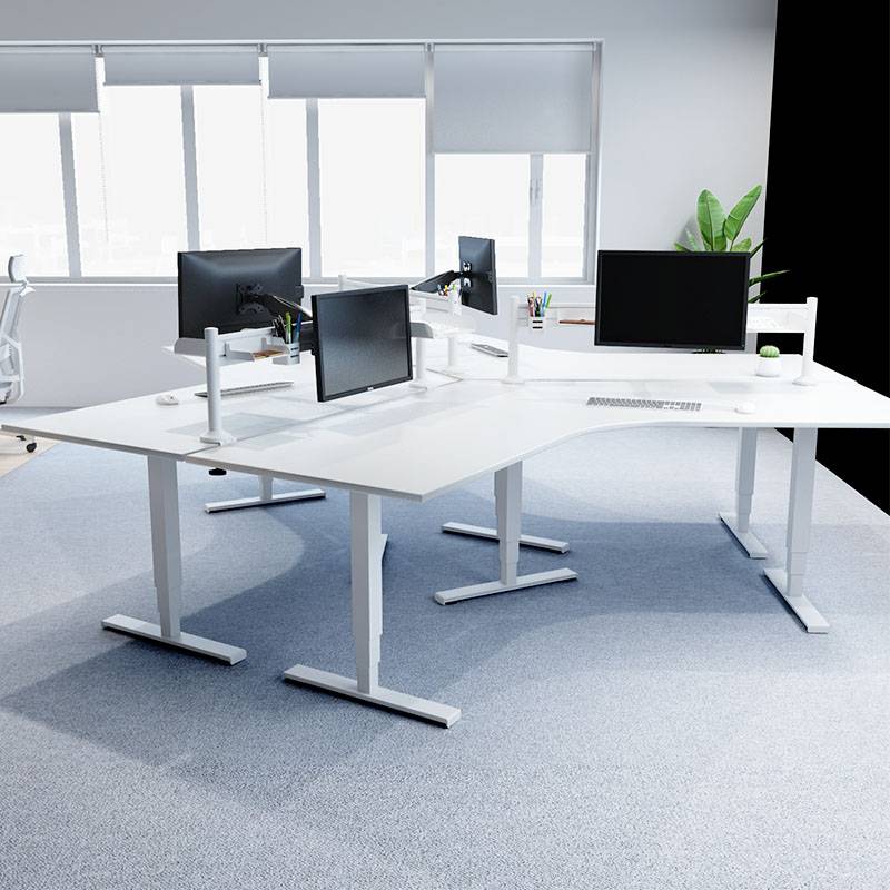 Zwei weiße höhenverstellbare Schreibtische in einem modernen Büro mit Monitoren und Pflanzen, viel Tageslicht durch große Fenster.