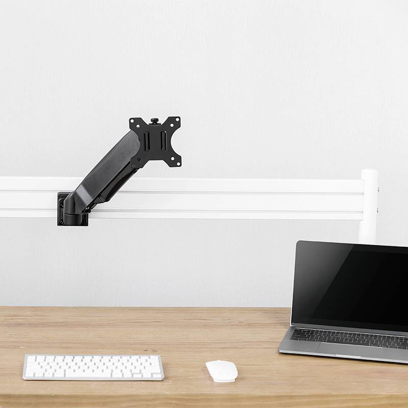 Ein leeres Schreibtisch-Szenario mit einem Laptop, einer Maus und einer Tastatur. Ein Monitorarm ohne Monitor ist ebenfalls sichtbar.