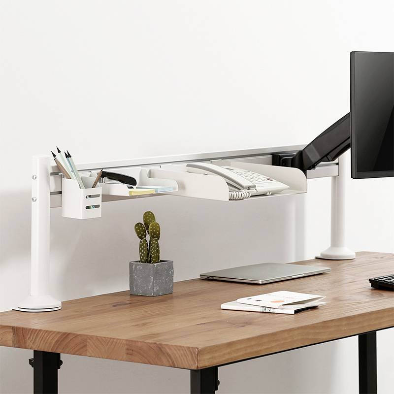 Ein moderner Schreibtisch mit Holzoberfläche. Darauf stehen ein Laptop, ein Monitorarm mit Bildschirm, ein Telefon und ein kleiner Kaktus.