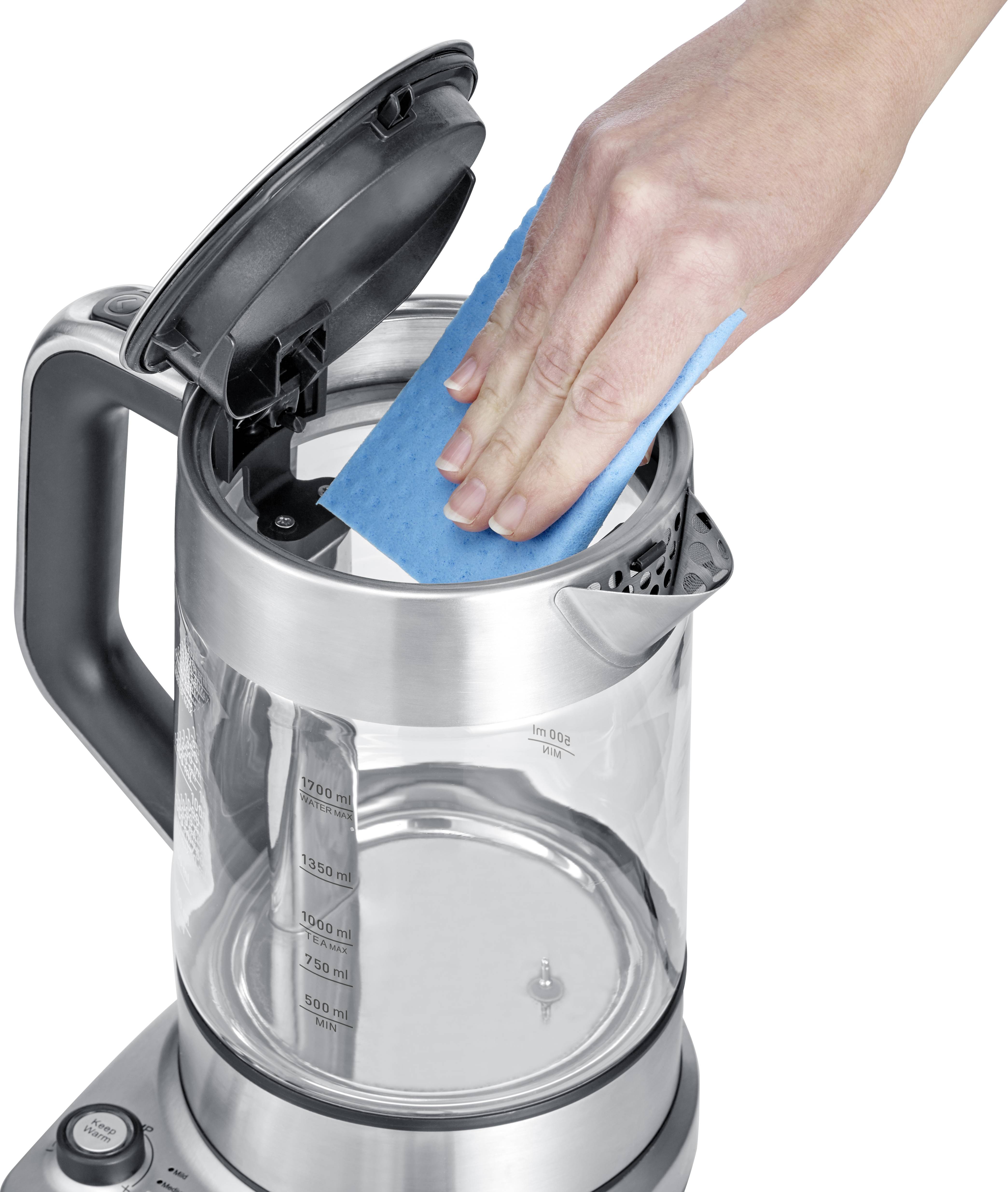 Eine Hand reinigt das Innere eines Wasserkochers mit einem blauen Schwamm. Der Deckel des Wasserkochers ist offen.