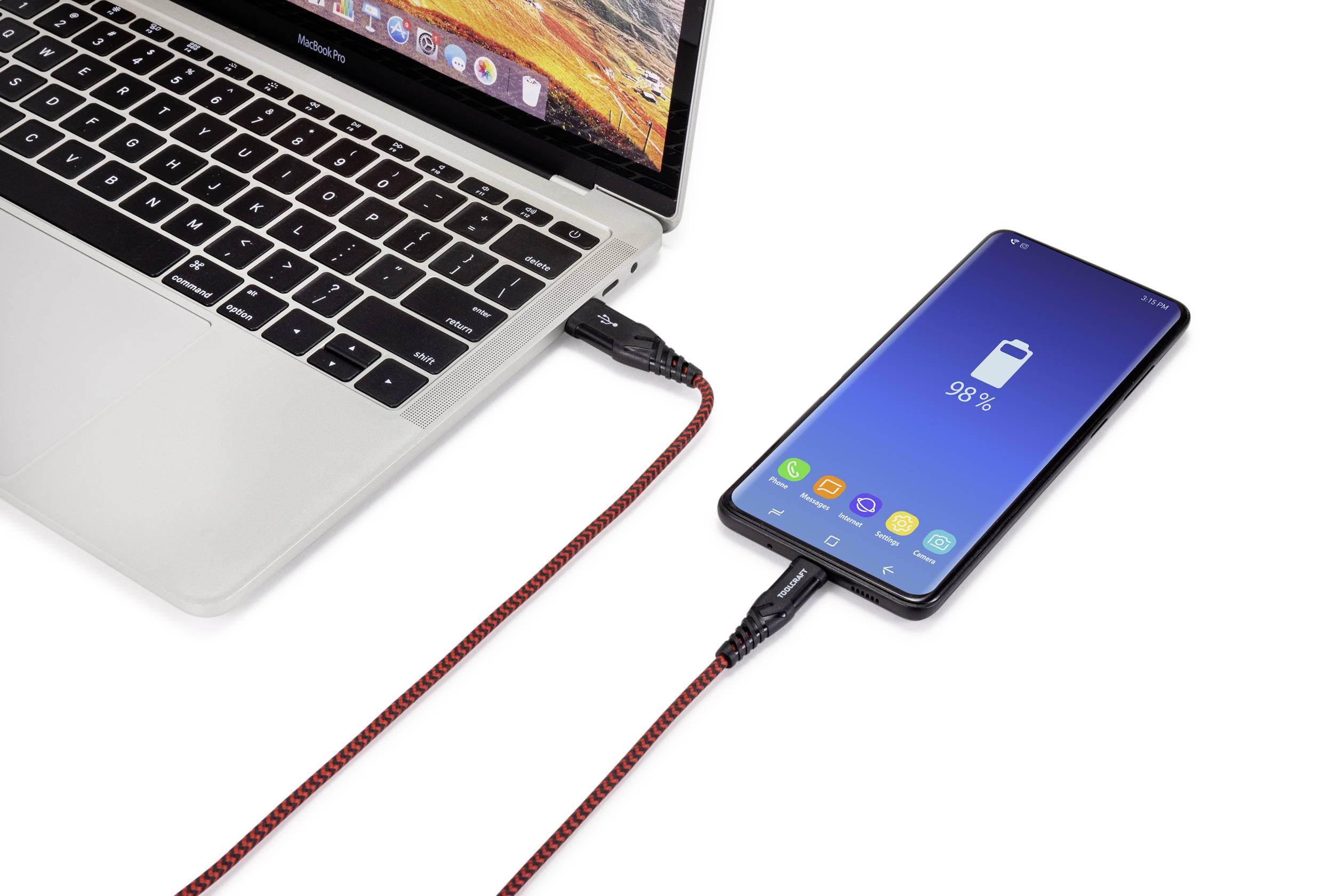Ein Laptop und ein Smartphone sind mit einem Ladekabel verbunden. Das Smartphone zeigt eine Batterieladung von 98 % an.