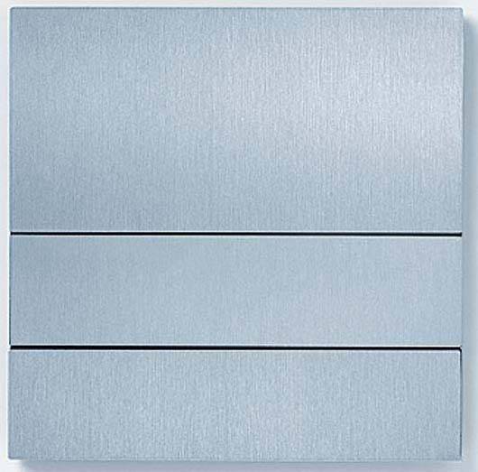 Ein quadratischer, metallisch glänzender Lichtschalter mit drei horizontalen Schaltflächen, geeignet für moderne Wohnräume.