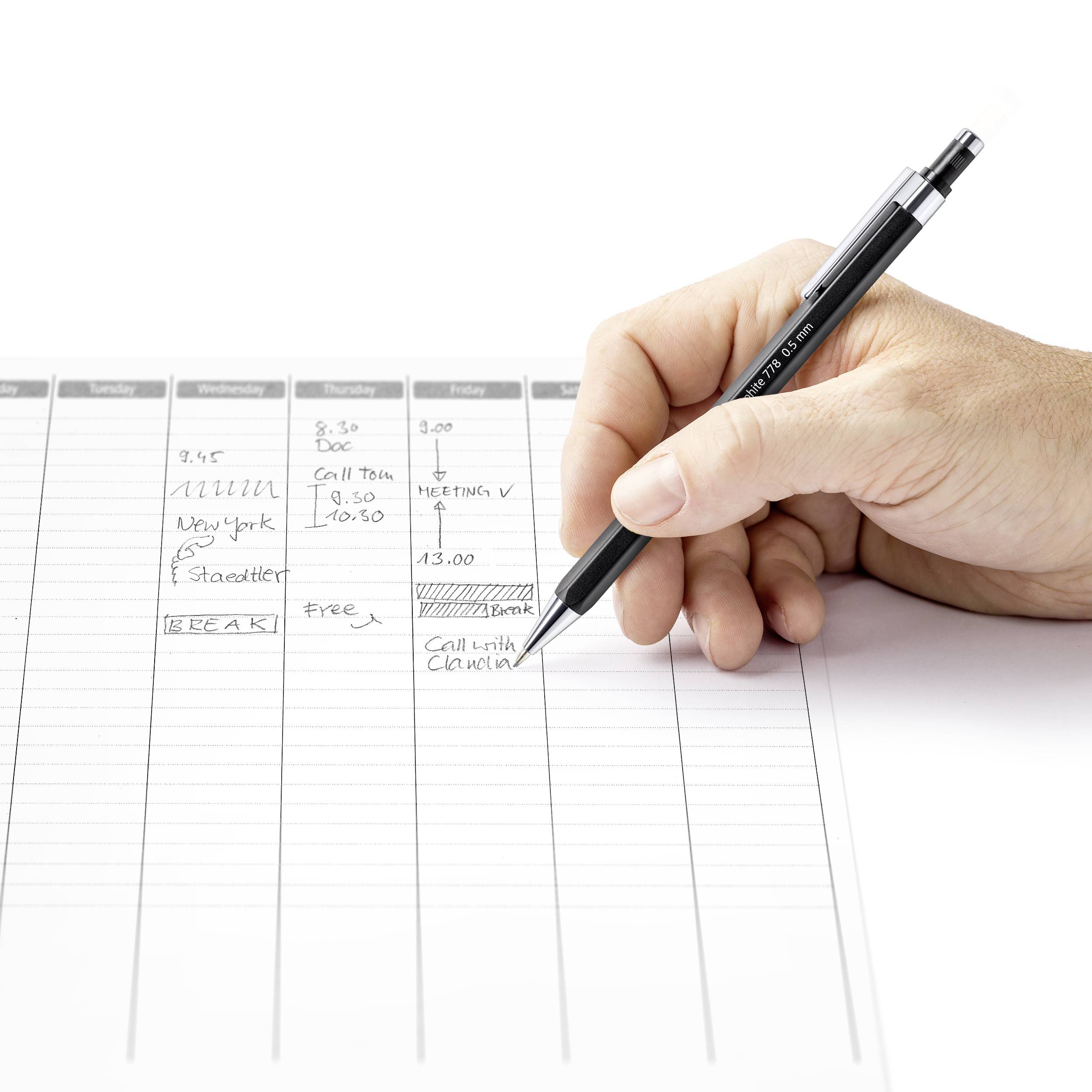 Eine Hand schreibt mit einem schwarzen Stift in einen Wochenplaner. Im Vordergrund stehen Termine für Treffen und Anrufe.