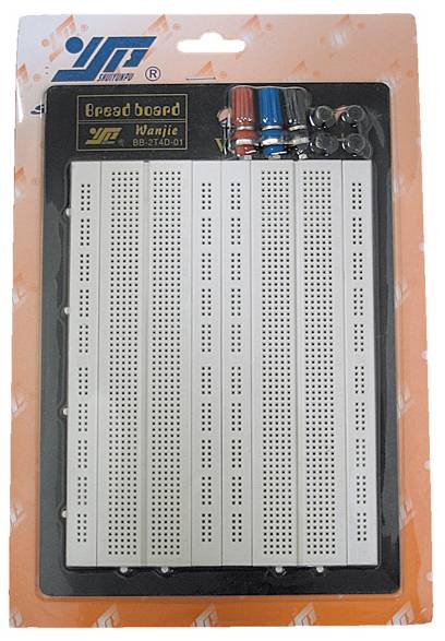 Ein Steckbrett (Breadboard) in einer Verpackung. Oberhalb des Steckbretts sind mehrere bunte Anschlussstifte zu sehen.