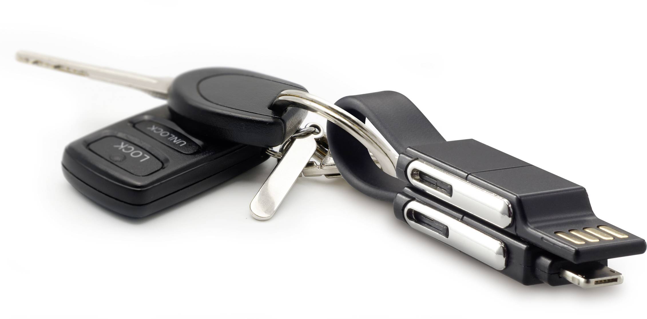 Ein Schlüsselbund mit einem Autoschlüssel, einem Schraubenschlüssel und zwei schwarzen USB-Sticks.