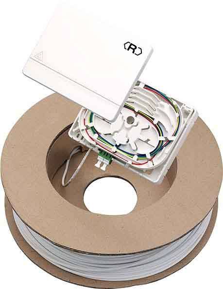Ein aufgerolltes Glasfaserkabel neben einem geöffneten Verteilerkasten mit sichtbarer Verkabelung und Anschlusspunkten.