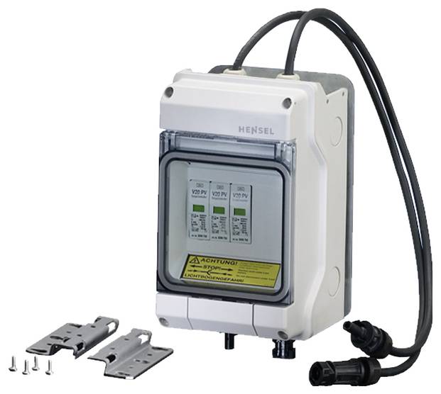 Elektrischer Schaltkasten mit sichtbaren Sicherungen, Kabelanschlüssen und Warnzeichen neben Montagezubehör.