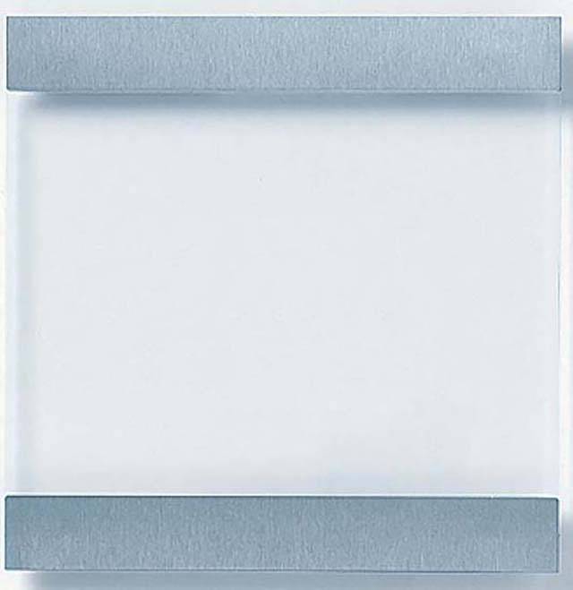 Ein quadratischer, durchsichtiger Glasblock mit zwei horizontalen, silbernen Streifen oben und unten. Minimalistisches Designobjekt.