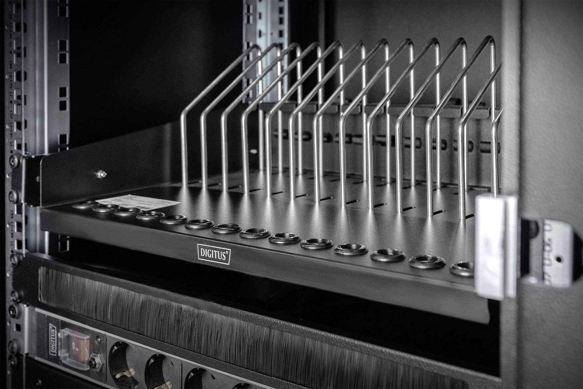 Netzwerkschrank mit einem Kabelmanagement-Regal und vertikalen Metallstangen zur ordentlichen Anordnung von Kabeln.