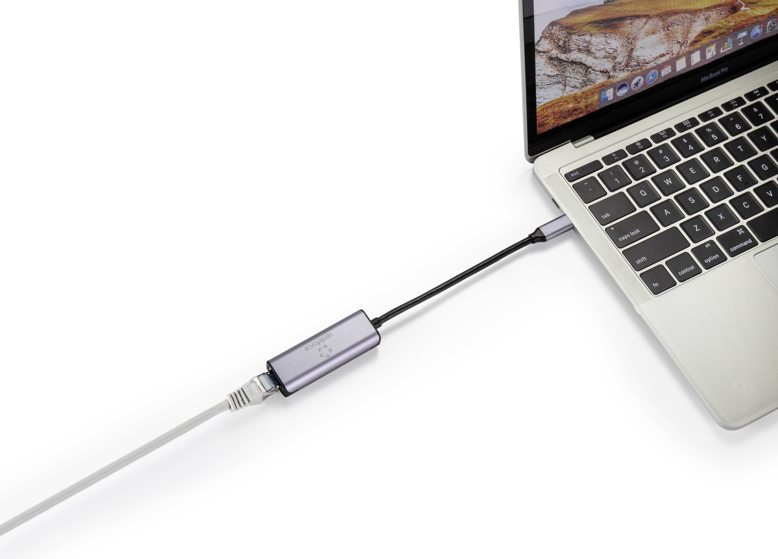 Ein Laptop ist über einen USB-Adapter mit einem Ethernet-Kabel verbunden. Das MacBook zeigt einen Sandhintergrund auf dem Bildschirm.