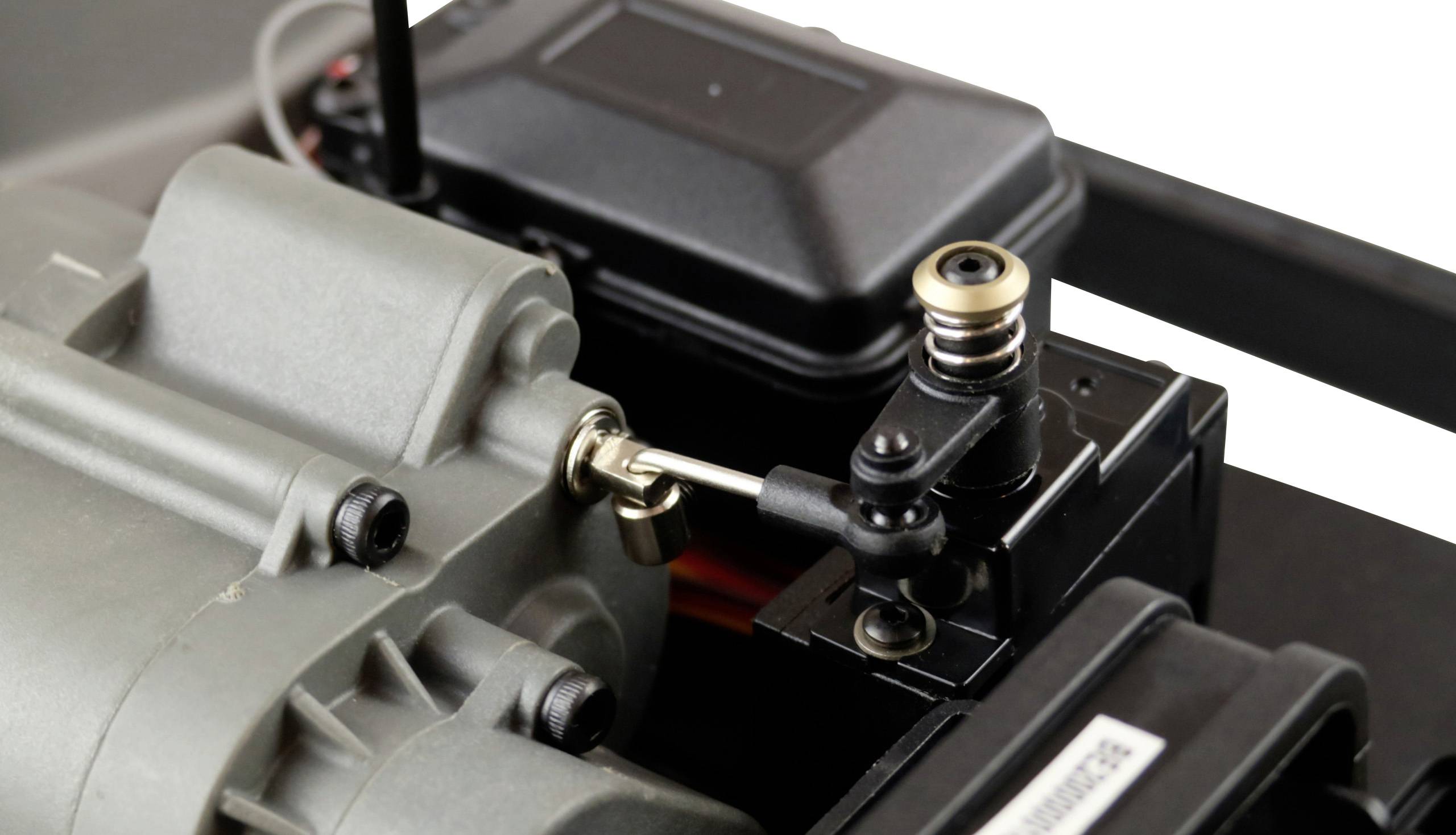 Nahaufnahme eines Modellbau-Servogetriebes mit Hebelarm, montiert an einem grauen Motor. Es zeigt die mechanischen Details der Verbindung.