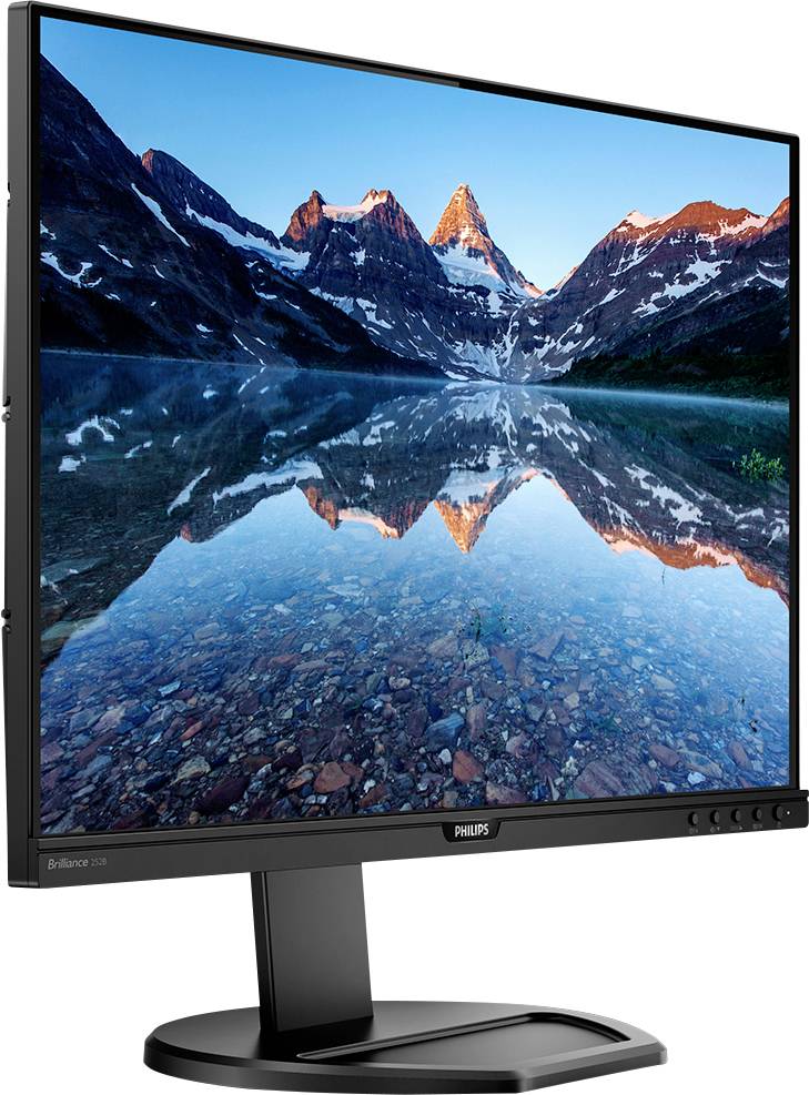 Ein Monitor zeigt ein Foto von Bergen, die im Wasser eines ruhigen Sees reflektiert werden. Lebendige Farben unter klarem Himmel.