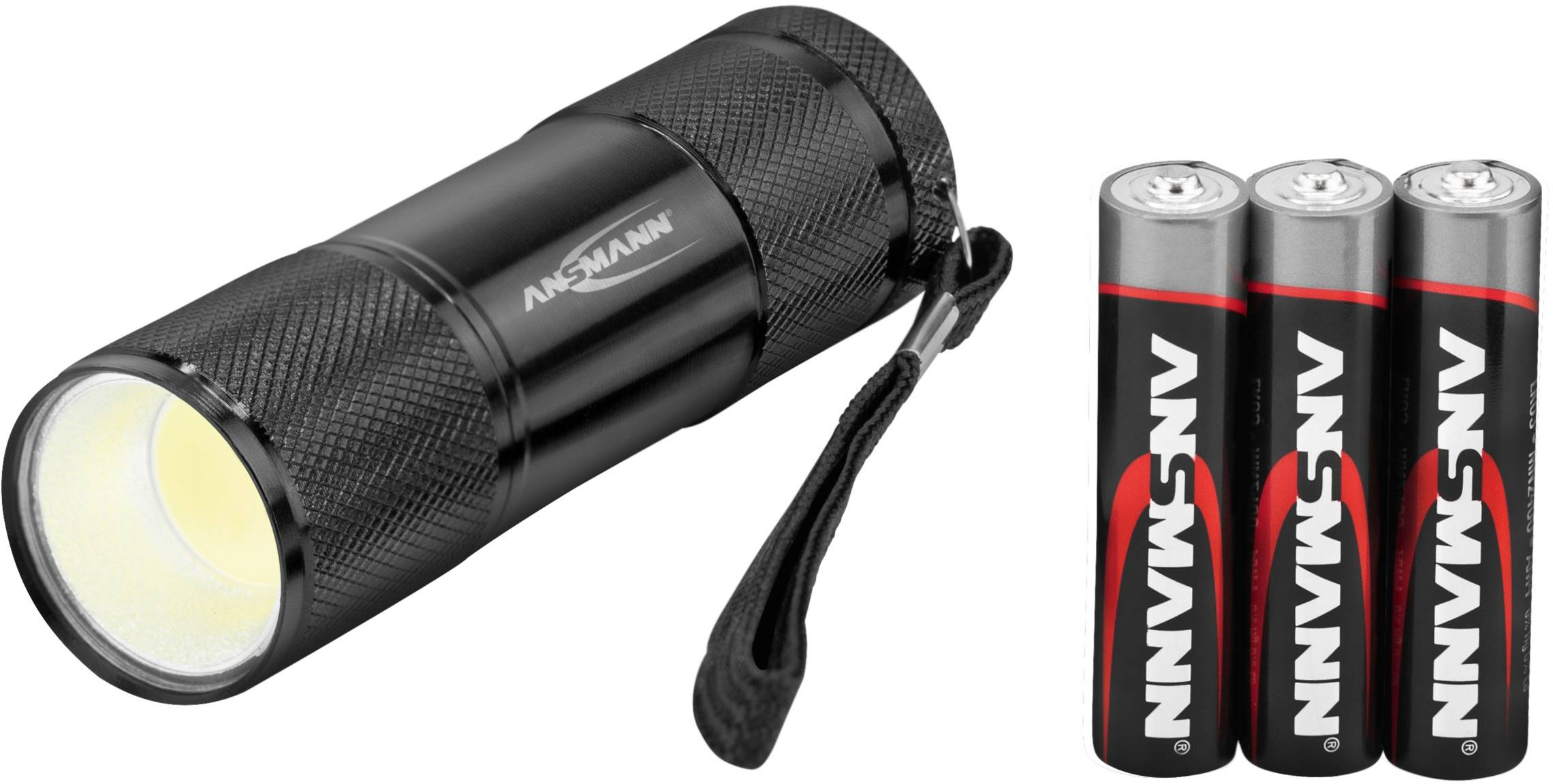 Schwarze Taschenlampe mit drei silber-roten Batterien daneben. Taschenlampe hat Aufdruck 'Ansmann'.