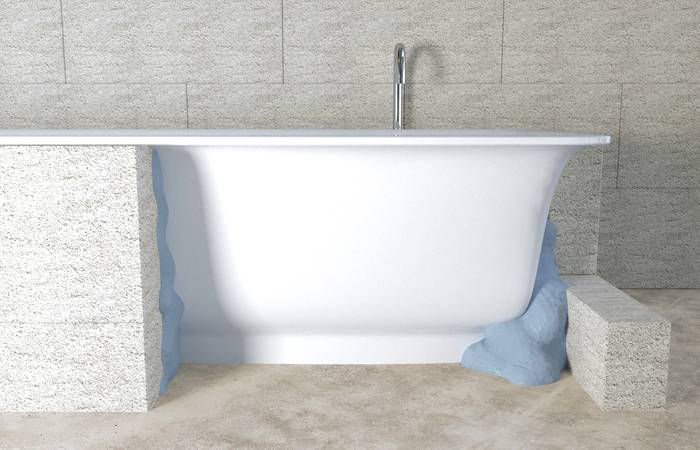 Freistehende weiße Badewanne in modernem Badezimmer mit grauen Wänden und hellem Steinboden.