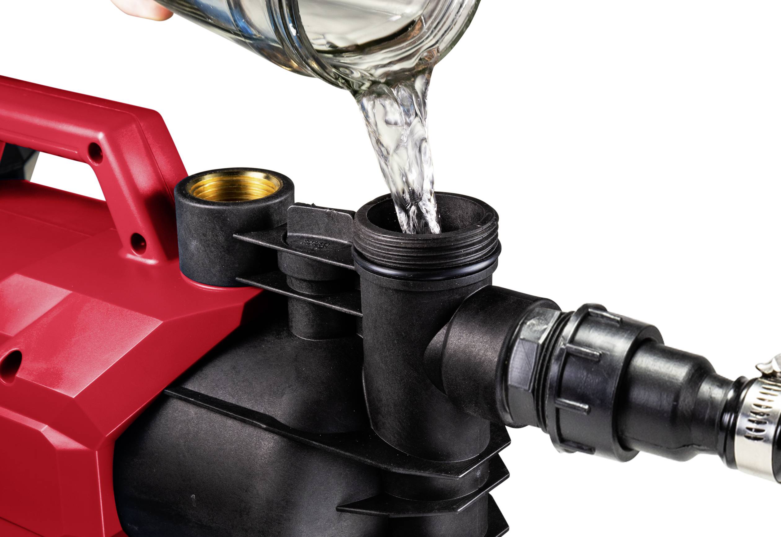 Rotes elektrisches Gerät mit schwarzem Schlauch; eine Flüssigkeit wird in die Öffnung gegossen.