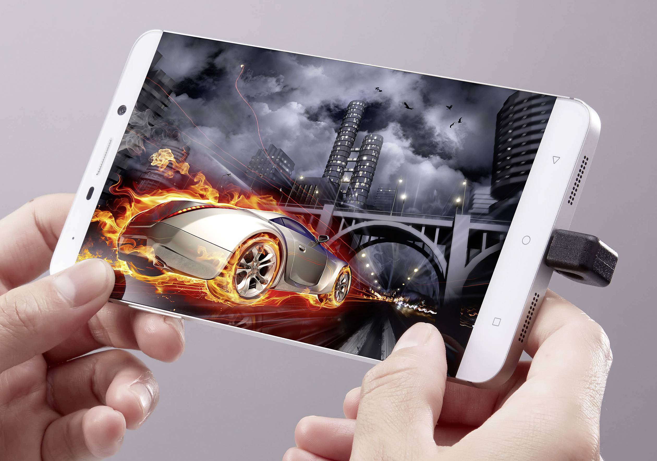 Eine Person hält ein Smartphone, das ein virtuelles Rennauto anzeigt. Das Auto hat Flammen und fährt durch eine städtische Kulisse bei Nacht.