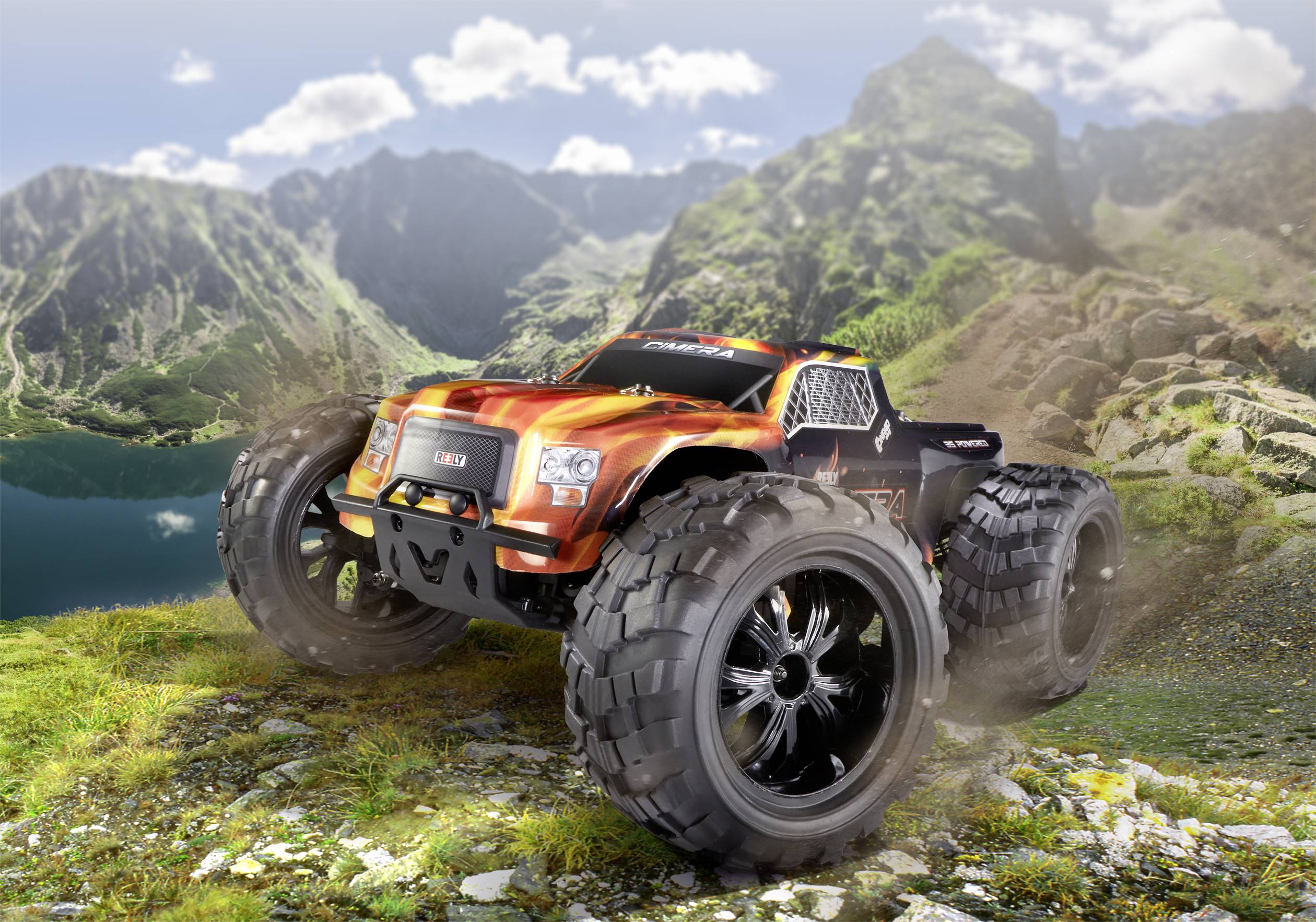 Ein orange-schwarzer RC-Monstertruck fährt über felsiges Gelände in einer Berglandschaft. Große Räder wirbeln Staub auf.