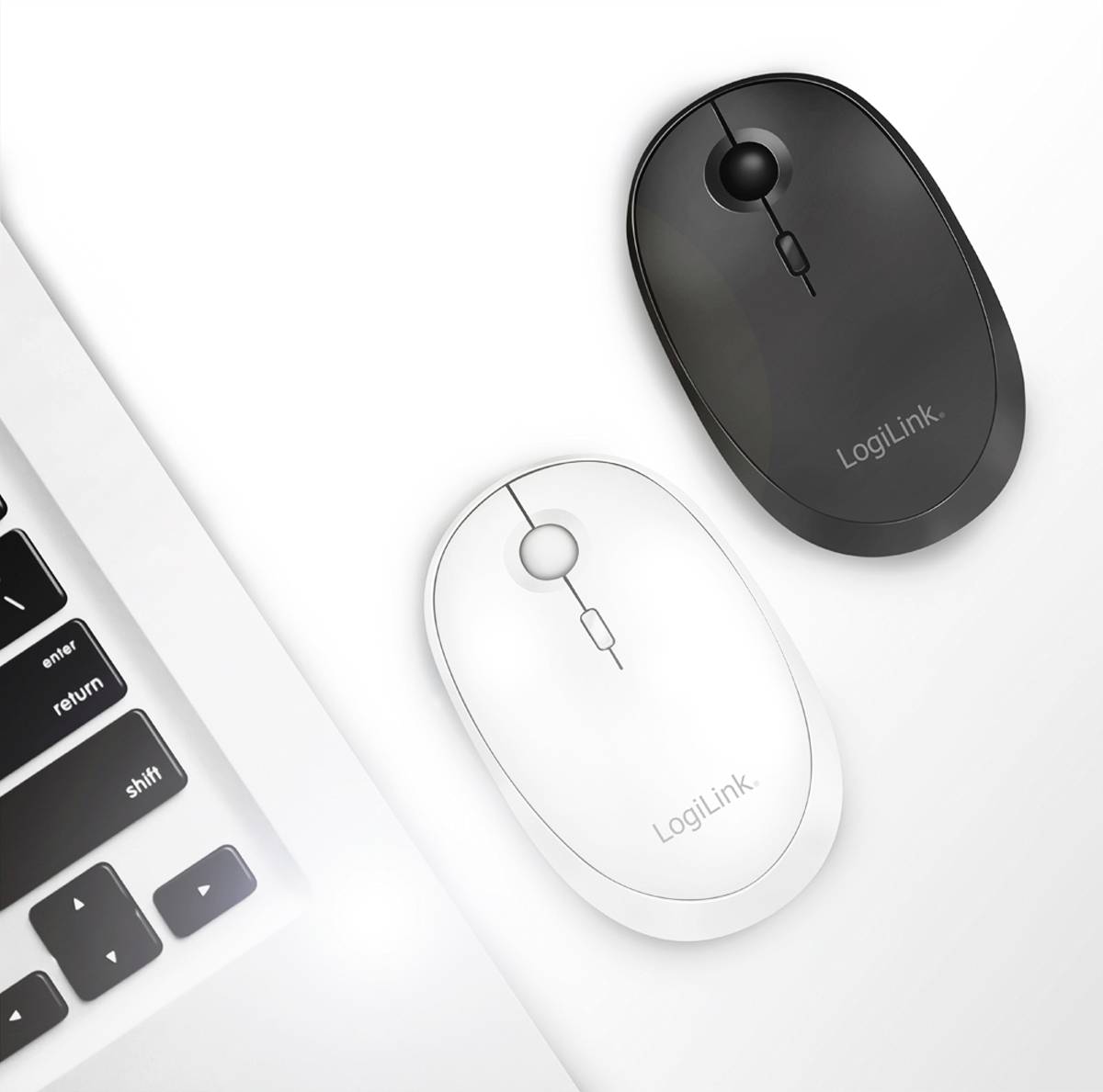 Zwei kabellose LogiLink-Mäuse, eine schwarze und eine weiße, liegen auf einem weißen Tisch neben einer teilweise sichtbaren Laptop-Tastatur.
