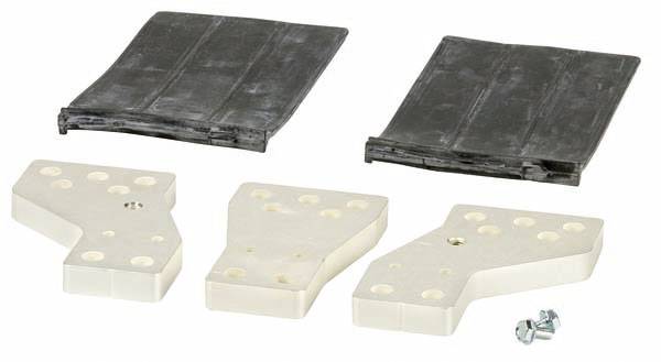 Zwei schwarze rechteckige Platten und drei beige, asymmetrisch gelochte Kunststoffteile auf weißem Hintergrund. Schrauben liegen daneben.