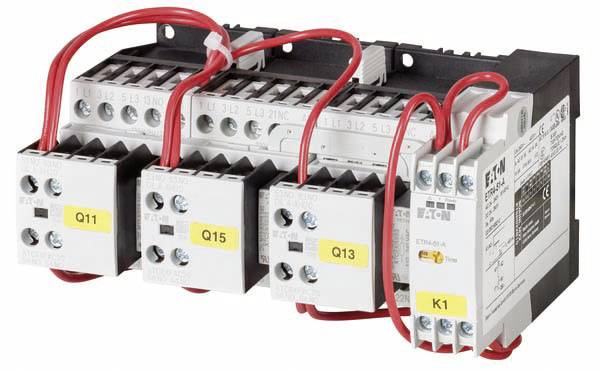 Ein elektrisches Schütz mit mehreren Schaltern und roten Kabeln, etikettiert mit 'Q11', 'Q15', 'Q13', und 'K1', montiert in einer Reihe.