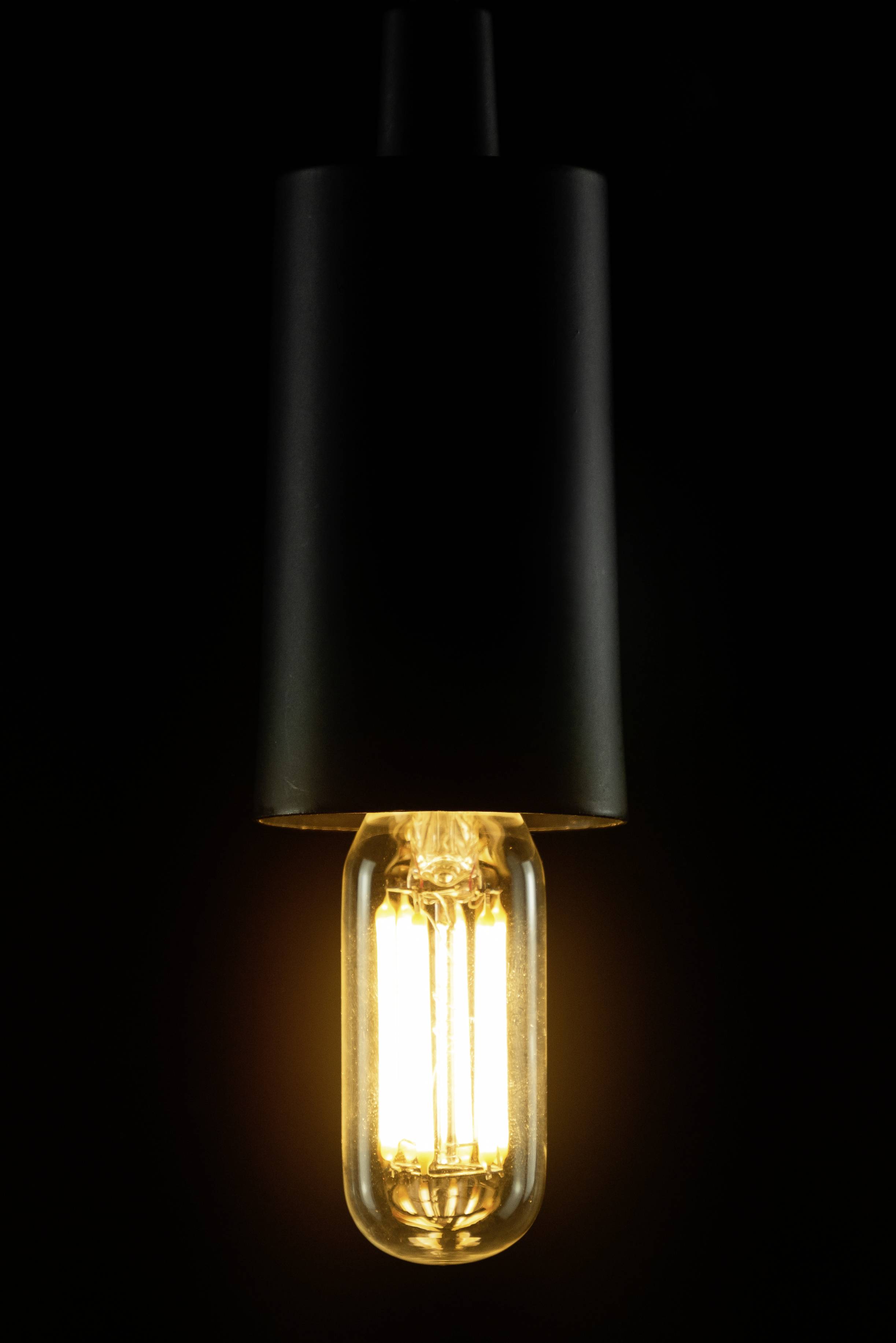 Eine leuchtende Glühbirne hängt von oben herab in einem dunklen Raum, erzeugt ein warmes, gelbes Licht, das den Raum dezent erhellt.