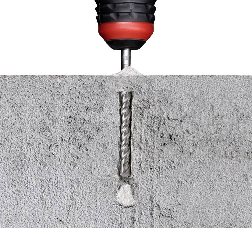 Nahaufnahme eines Bohrers, der ein Loch in einen grauen Betonblock bohrt. Der Bohrer erzeugt Staub und feinen Betonabrieb.