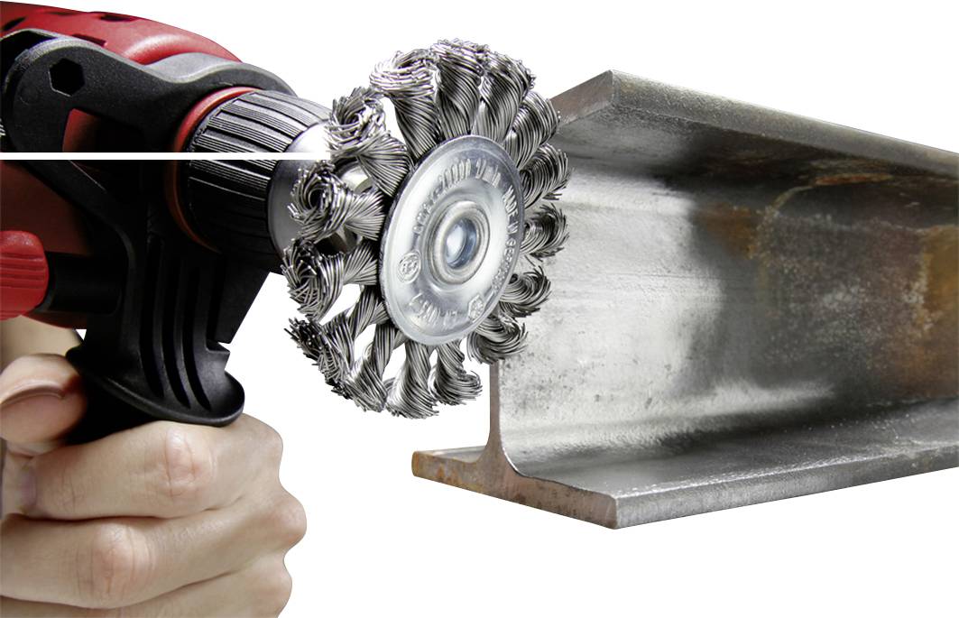Eine Hand hält eine Bohrmaschine mit Drahtbürstenaufsatz, der zur Reinigung eines Metallträgers verwendet wird.