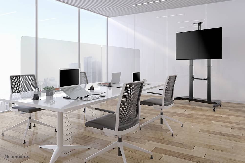 Moderner Besprechungsraum mit großen Fenstern, sechs Drehstühlen, einem großen Tisch mit Laptops und einem Präsentationsbildschirm.