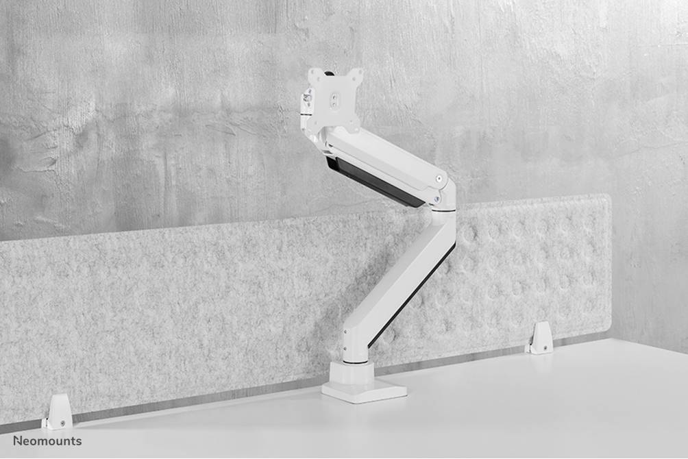 Höhenverstellbarer Monitorarm mit grauer Wand als Hintergrund, montiert auf einem weißen Schreibtisch.