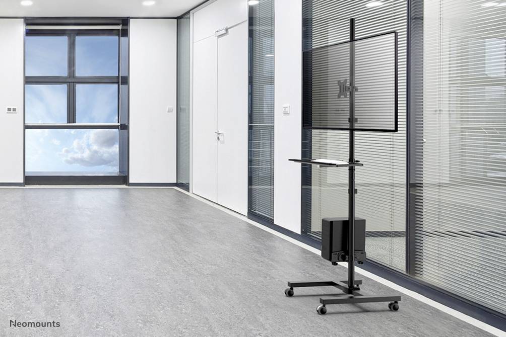 Ein moderner Besprechungsraum mit einem großen Fenster links. Rechts ein rollbarer Bildschirmständer mit geneigtem Bildschirm und Ablagefläche.