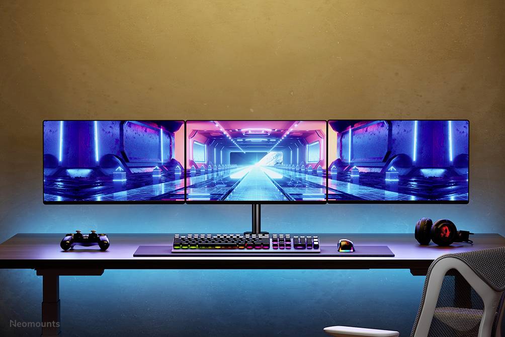 Ein Gaming-Schreibtisch mit drei Monitoren zeigt ein futuristisches Spiel. Darunter eine Tastatur, Maus und Kopfhörer vor einem beleuchteten Hintergrund.