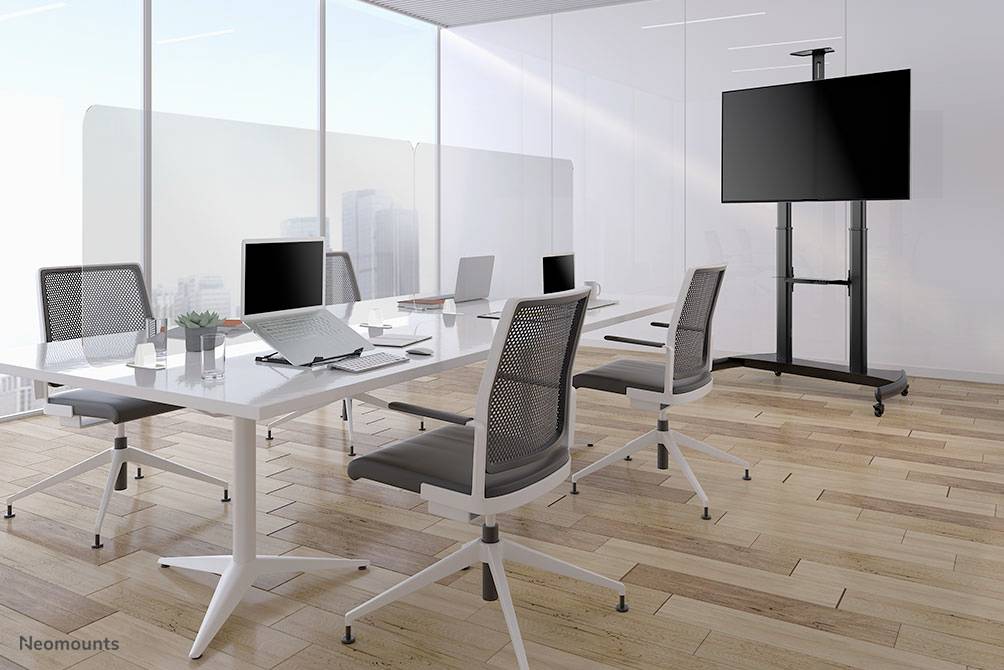 Moderner, heller Konferenzraum mit weißem Tisch, vier Bürostühlen, Laptop, Notizbuch und Flachbildschirm auf Ständer. Fensteraussicht auf Stadt.