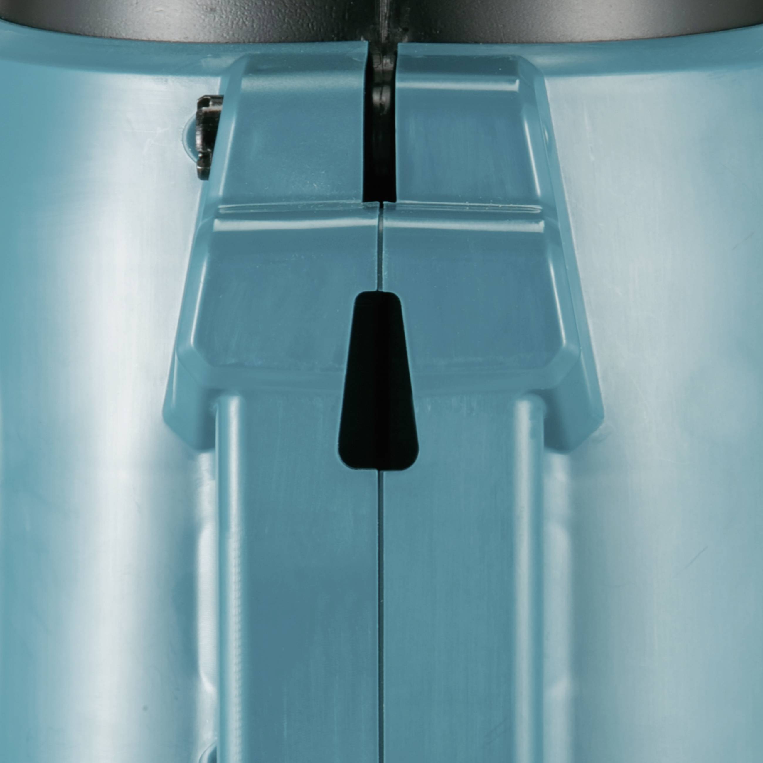 Ausschnitt einer Maschine in Nahaufnahme, die eine zentrale Komponente aus Metall und Kunststoff zeigt, mit einem Schlitz in der Mitte.