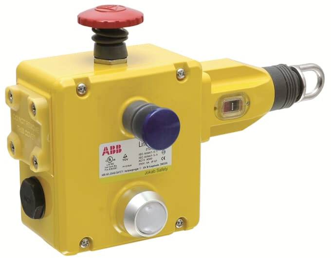 Gelbes Sicherheitsgerät mit rotem Not-Aus-Knopf und mehreren Anschlüssen, verwendet in industriellen Anwendungen zur Sicherheitskontrolle.