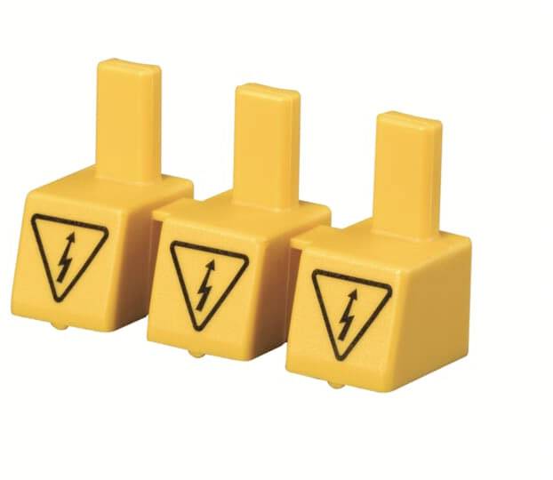 Drei gelbe Plastikschalter mit Blitzsymbolen weisen auf elektrische Gefahr hin. Sie stehen in einer Reihe.
