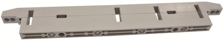 Ein graues, rechteckiges Teil mit mehreren Löchern und Aussparungen, möglicherweise ein Bauteil für Konstruktionen oder technische Zwecke.