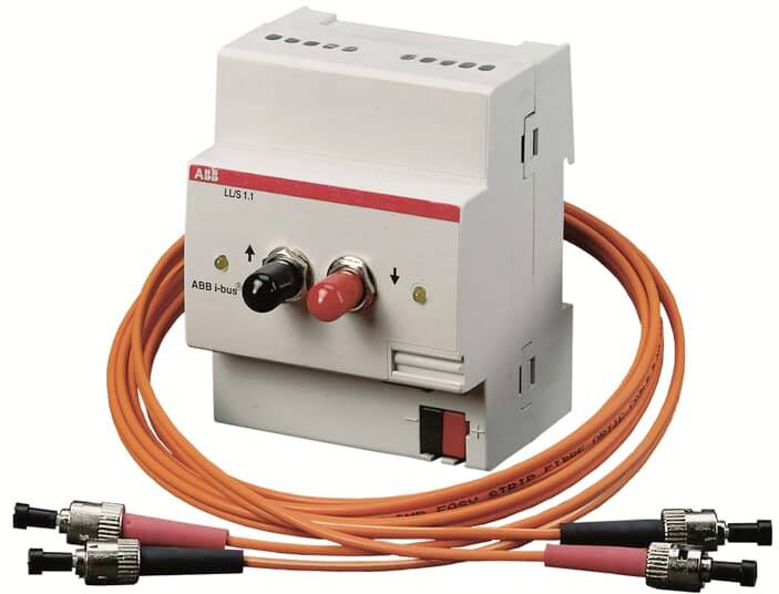 Ein weißes elektrisches Gerät mit zwei Steckern und mehreren orangefarbenen Kabeln mit Steckverbindern.