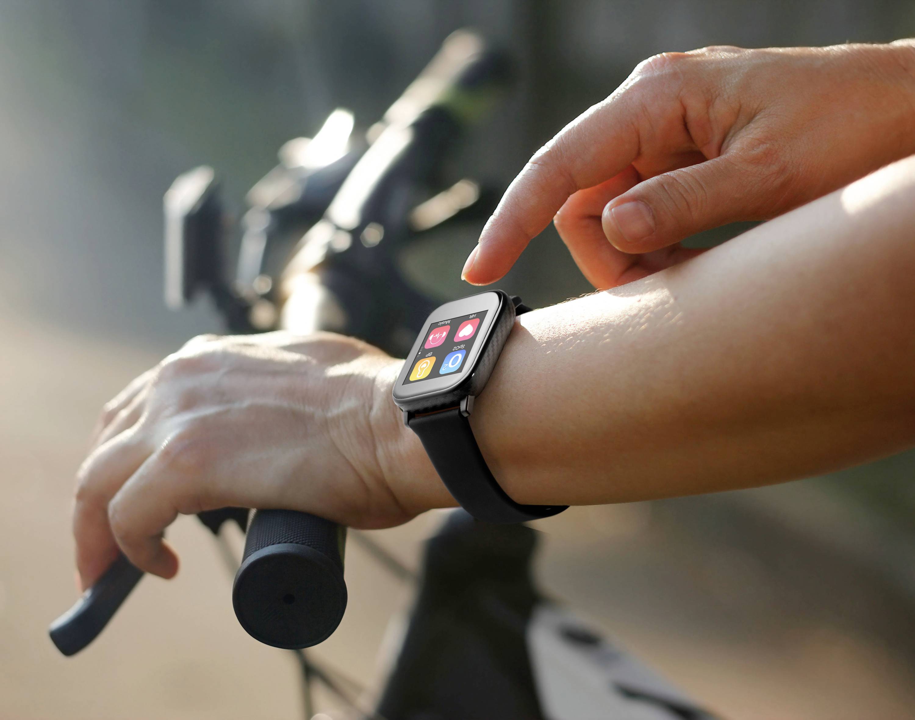 Eine Person überprüft eine Smartwatch beim Fahrradfahren. Die Uhr zeigt bunte Apps an.