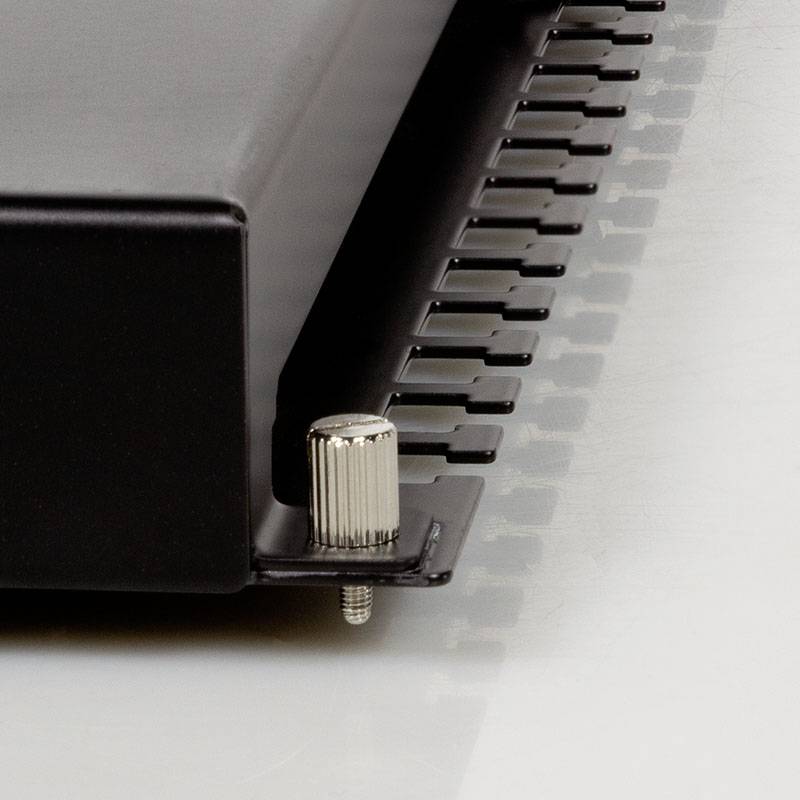 Nahaufnahme eines Metallgehäuses mit Befestigungsschraube und Kühlrippen. Technisches Detail eines elektronischen Geräts.