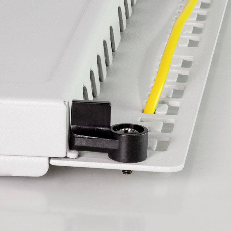 Ein graues Kunststoffgehäuse mit einer gelben Kabelverbindung und Kunststoffhalterungen darauf montiert.