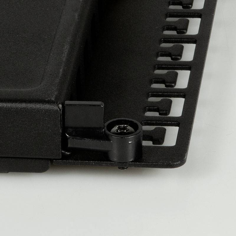 Ein schwarzes Kunststoffteil mit rechteckiger Form und gezackten Kanten. Es scheint ein mechanisches oder technisches Bauteil zu sein.