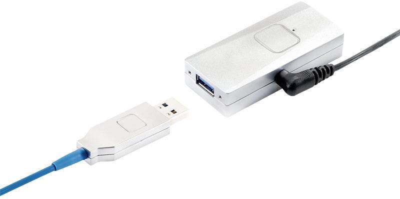 Ein silbernes USB-Gerät mit zwei Anschlüssen, verbunden über ein blaues Kabel und ein schwarzes Netzkabel, möglicherweise ein Adapter.