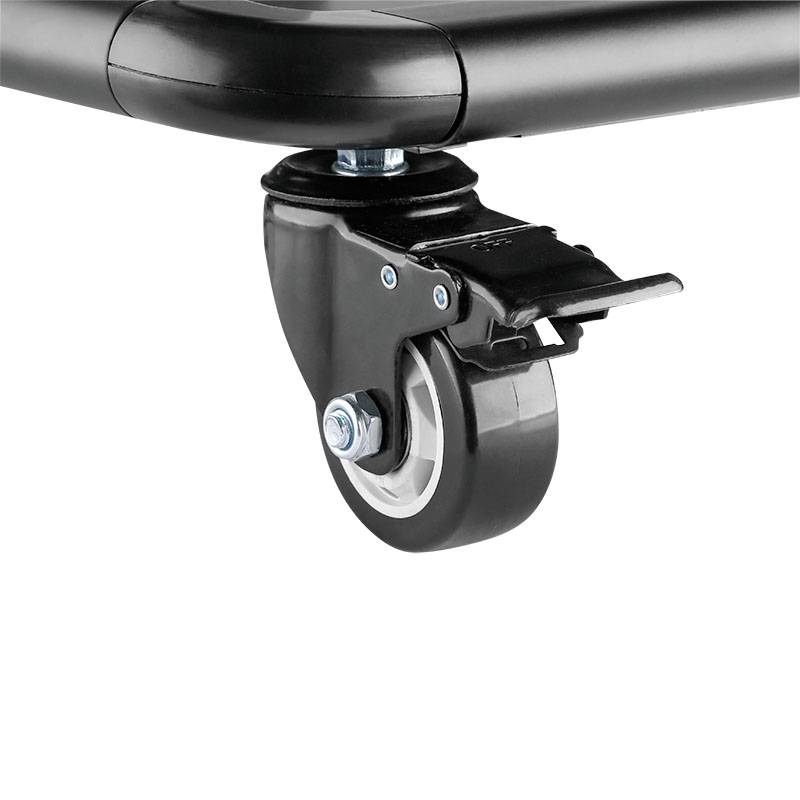 Nahaufnahme eines schwarzen Transportrollenrads mit einer Bremse, befestigt an der Ecke eines Möbelstücks oder einer Transportkarre.