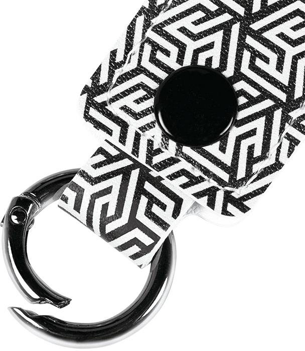 Ein Schlüsselanhänger mit schwarz-weißem geometrischem Muster und rundem schwarzen Knopf.